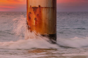 Image of a corroded metal surface or a structure affected by environmental factors.